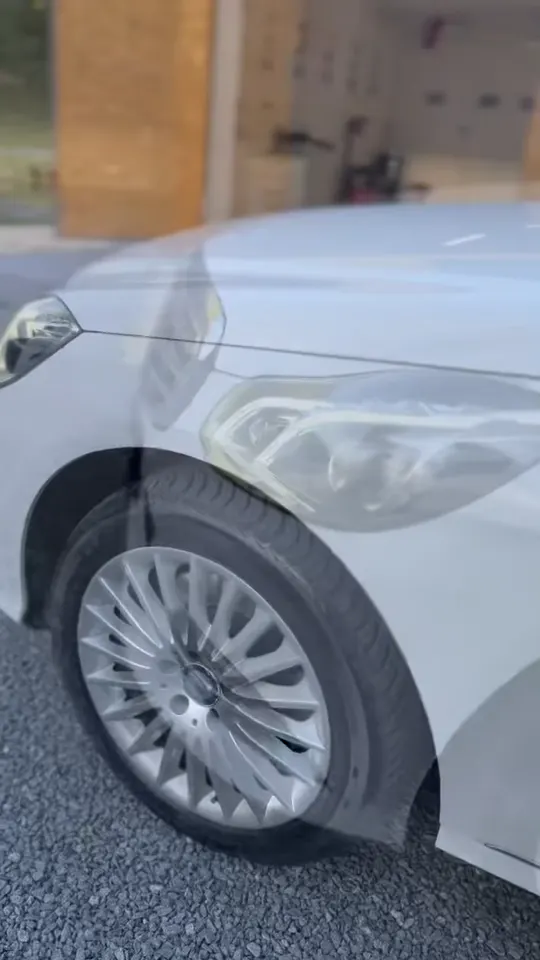 Biely Mercedes E-Class kombi na štrku pred štúdiom: koleso, bok a zadné dvere