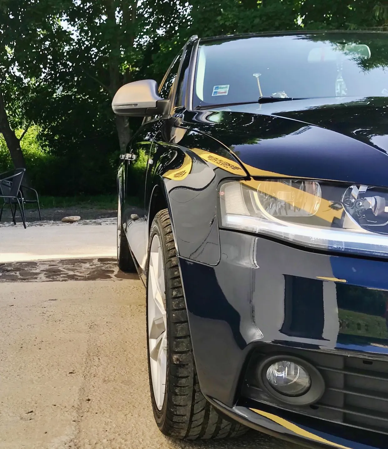 Front wing and headlight of a blue Audi A4 Avant in the sun after paint correction, our first job